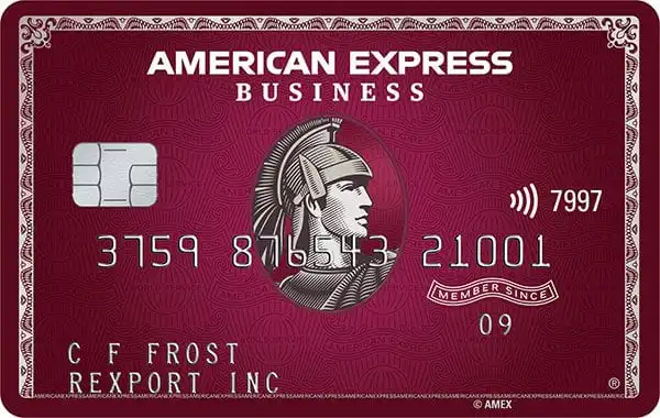 American Express Business credit card in burgundy color with a silver chip, contactless symbol, and an image of a centurion helmet in the center. Cardholder name and company appear at the bottom.