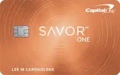 A Capital One SavorOne credit card with a copper-orange background and circular patterns, featuring the card chip, SavorOne logo, and cardholder name.