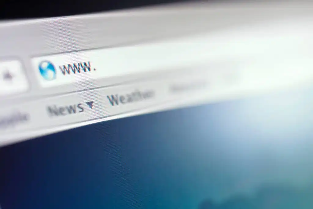 A close-up of a web browsers address bar displaying www. with tabs below labeled News and Weather in a blurred, blue-toned background.