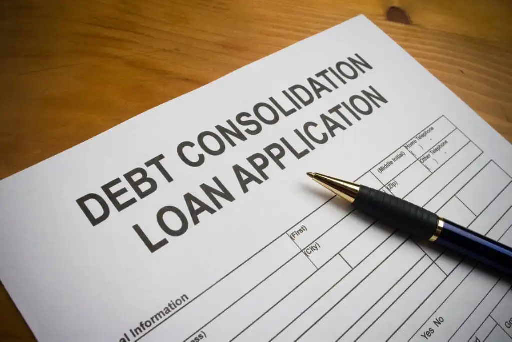 A debt consolidation loan application form with a black and gold pen resting on top, placed on a wooden surface.