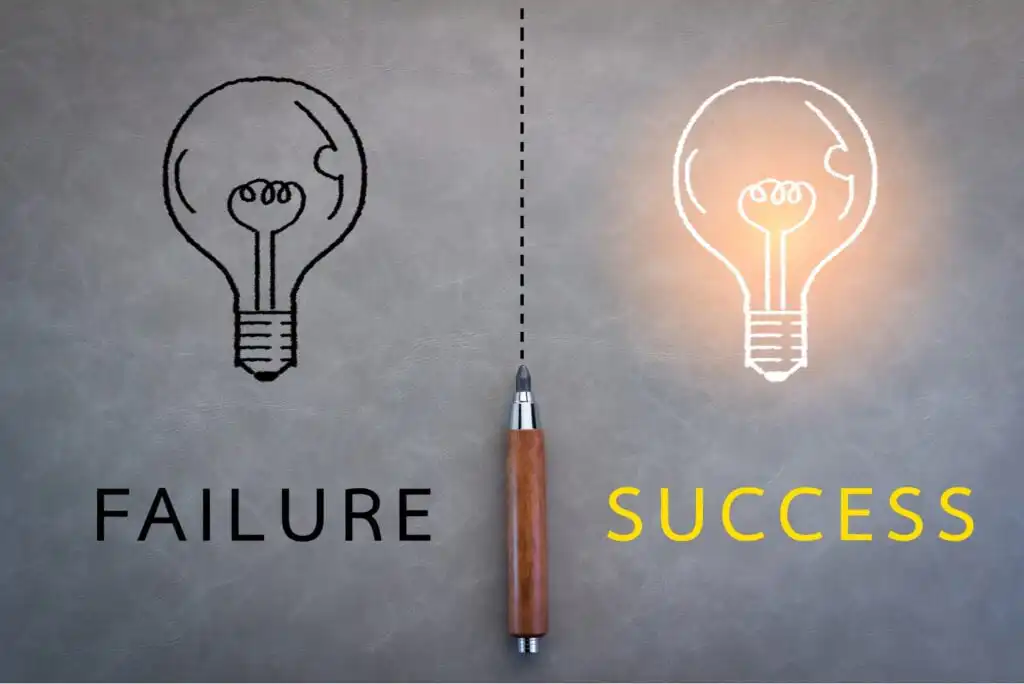 A lightbulb illustration divided in half with a pen in the center; the left side says FAILURE with a dark bulb, while the right says SUCCESS with a glowing bulb.