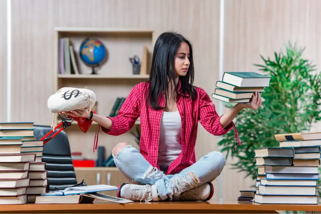 A young woman sits cross-legged on a desk, holding a stack of books in one hand and a money bag in the other, surrounded by more books, symbolizing the choice between education and money.