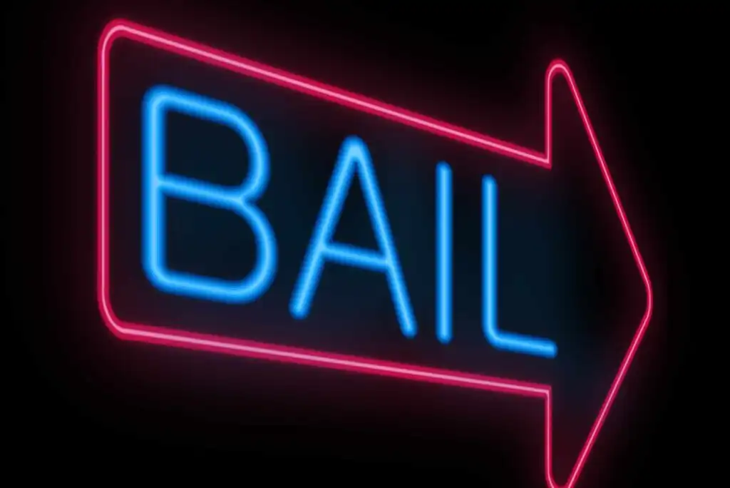 A neon sign with the word BAIL in blue letters inside a pink outlined arrow pointing to the right, against a black background.