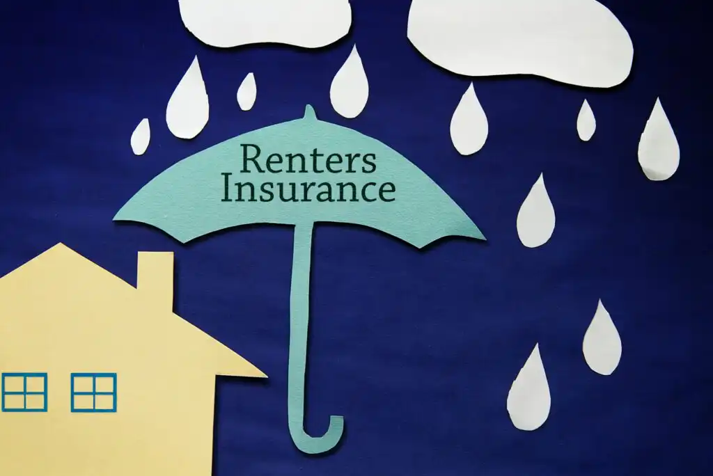 A paper cutout of a house next to an umbrella labeled Renters Insurance, shielding it from falling raindrops and clouds, symbolizing protection.
