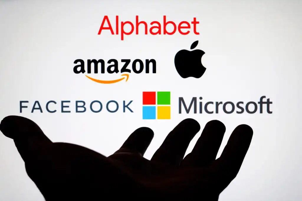 A silhouette of an open hand supports the logos of major tech companies: Alphabet, Amazon, Apple, Facebook, and Microsoft on a white background.